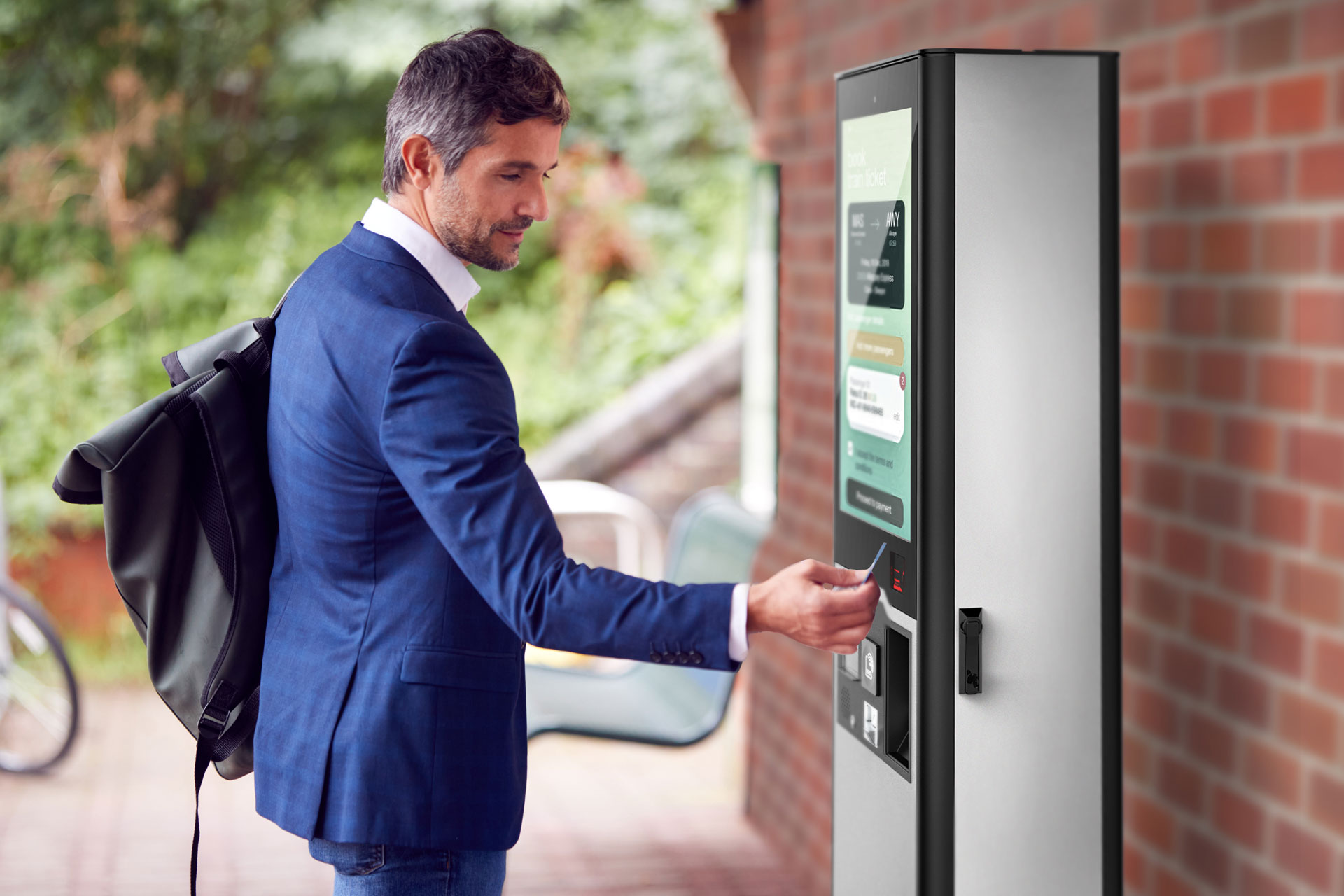 Un hombre utiliza el exterior para comprar billetes en una estación de ferrocarril