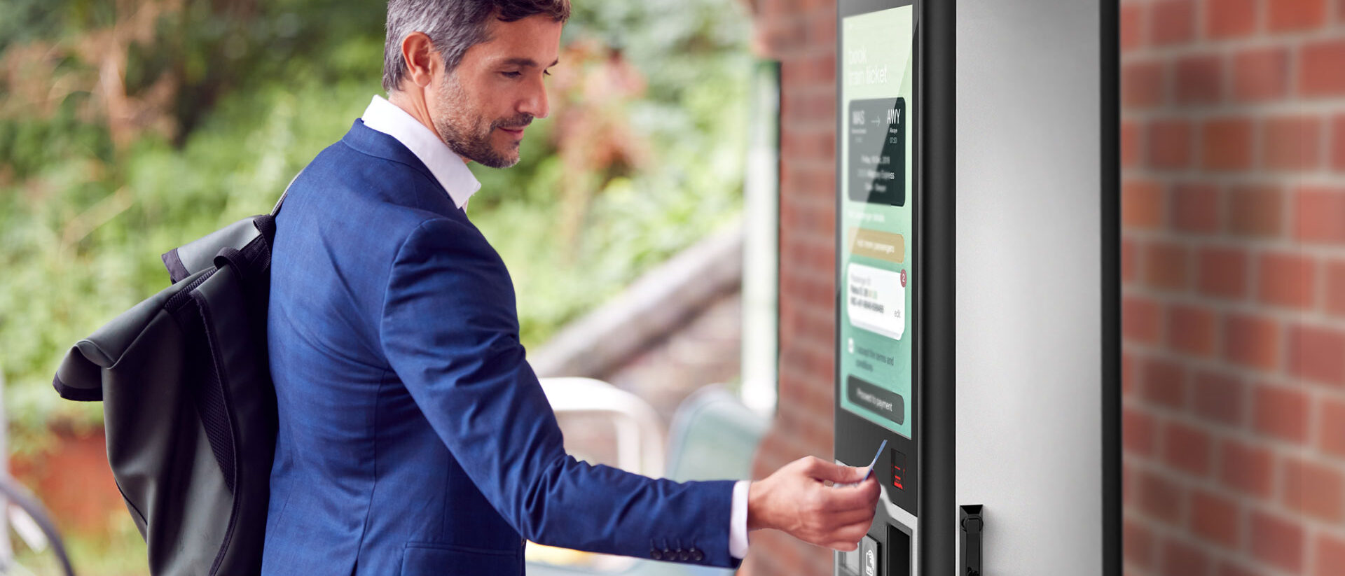 Un hombre utiliza el exterior para comprar billetes en una estación de ferrocarril