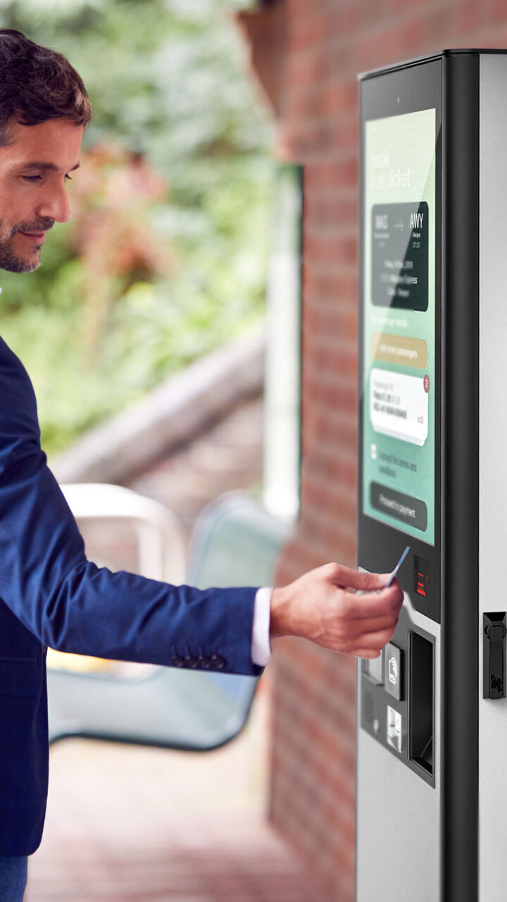 Un hombre utiliza el exterior para comprar billetes en una estación de ferrocarril